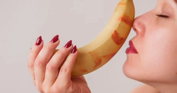 Woman holding a banana covered with lipstick