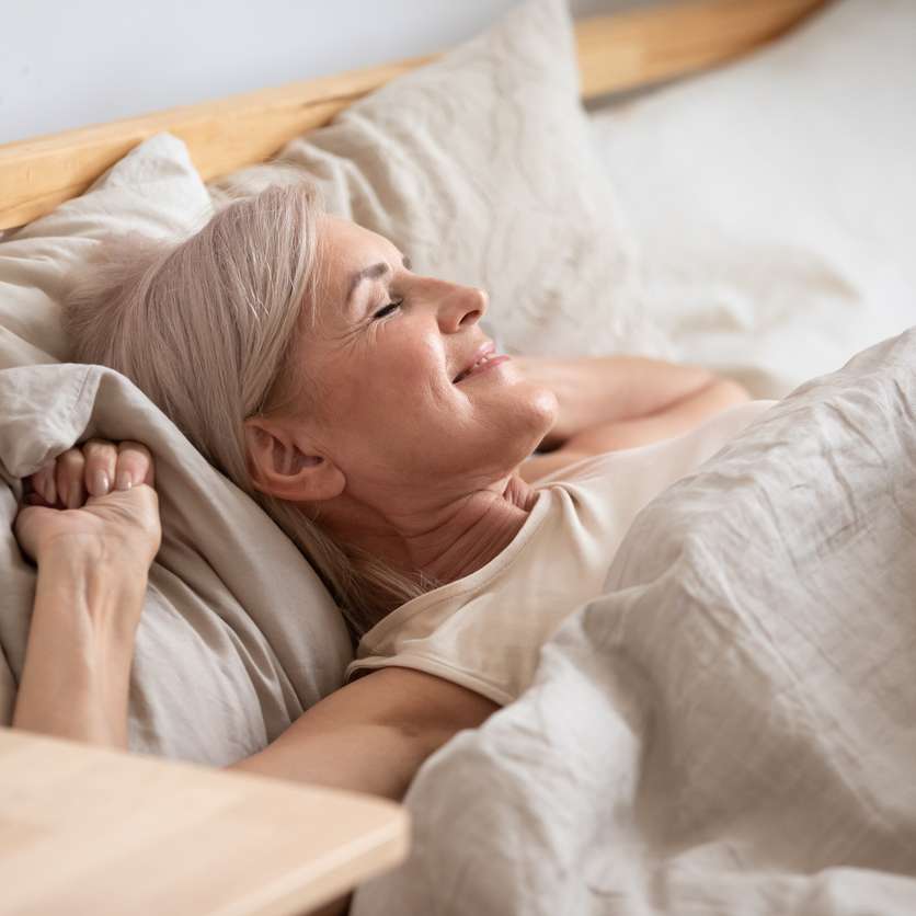 Older woman in bed smiling