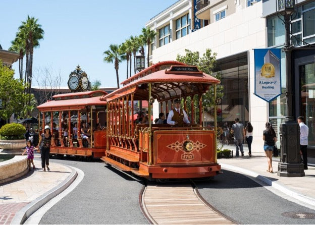 A traditional red trolley ambling along the charming streets of Glendale, CA