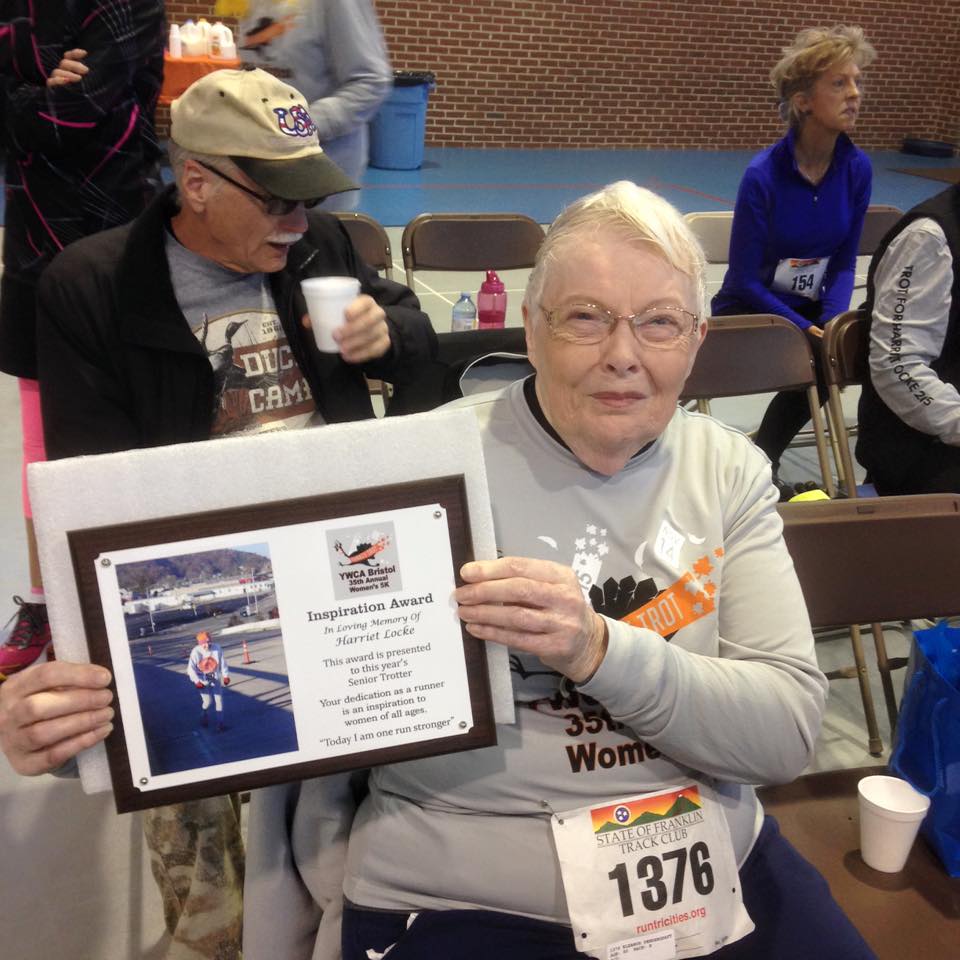 Eleanor holds up a track club inspiration award.