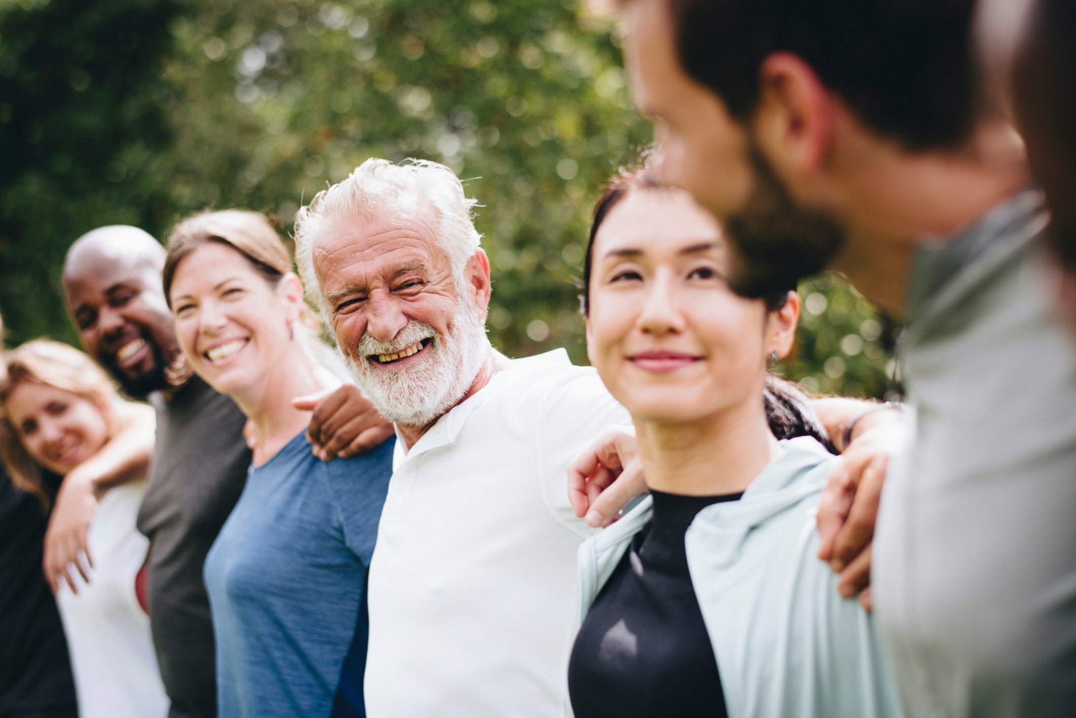 A group of people with their arms around each other's shoulders.