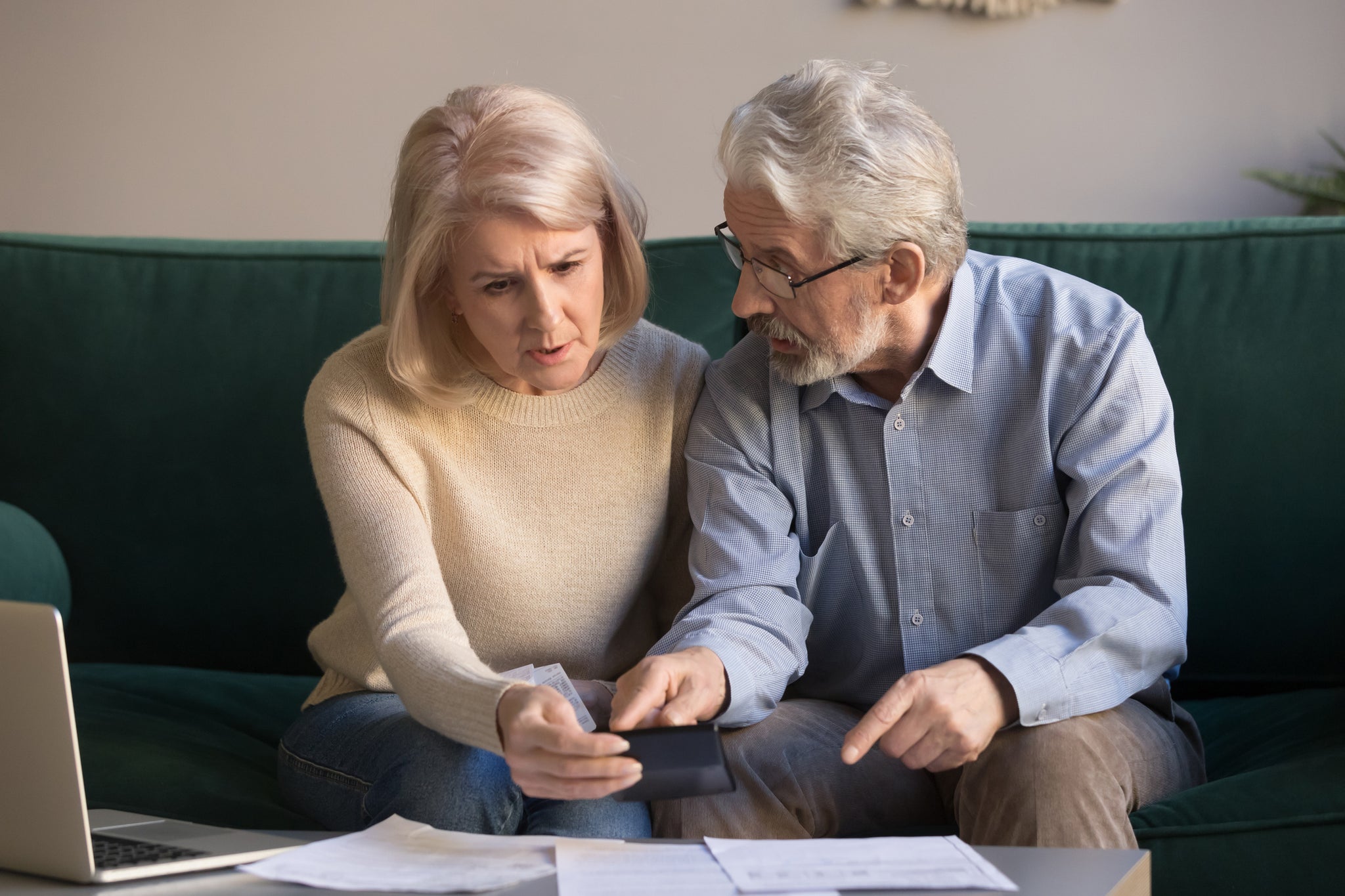 Two people look confused over paperwork.