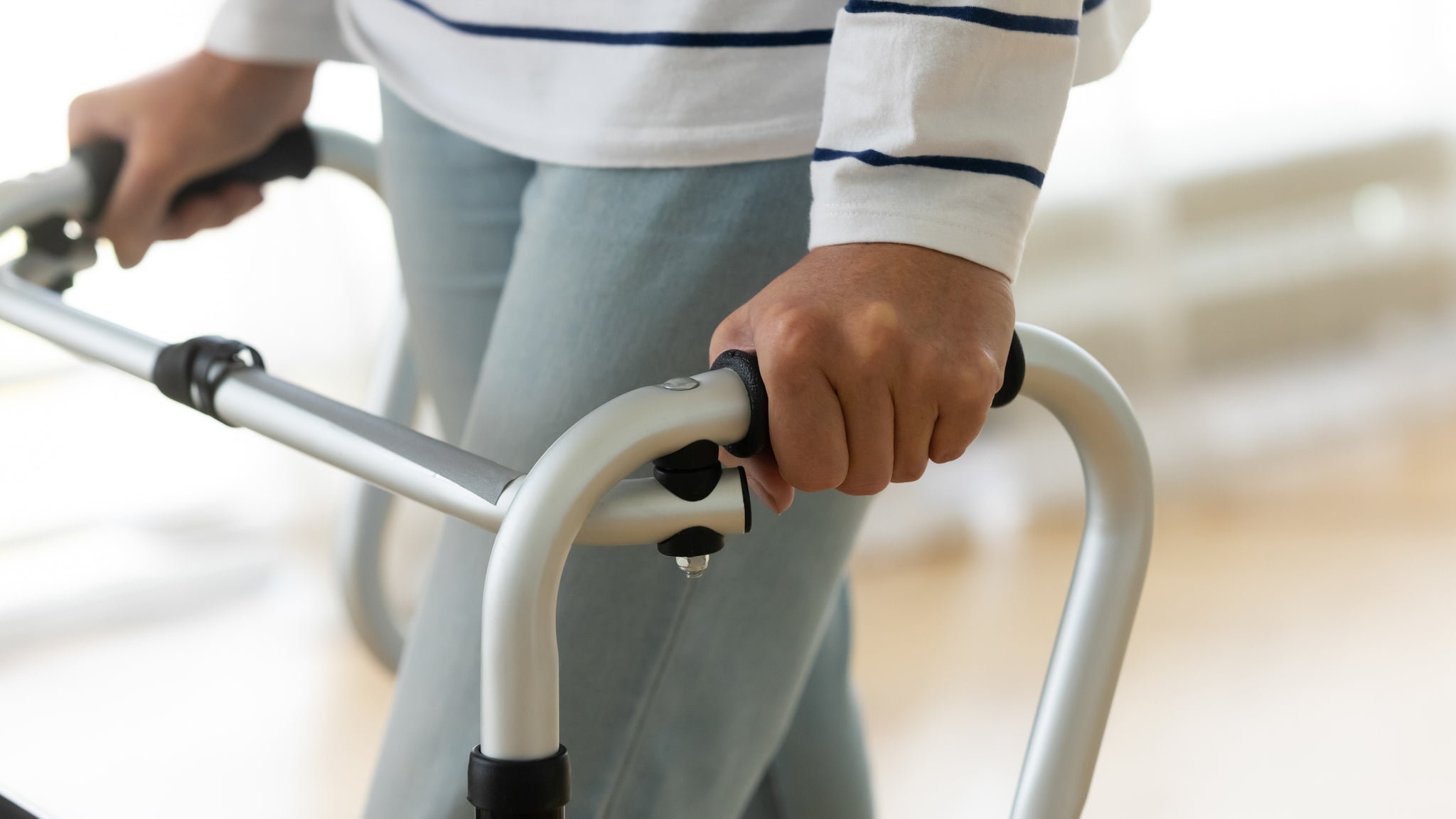 A close-up picture of a person using a rollator.