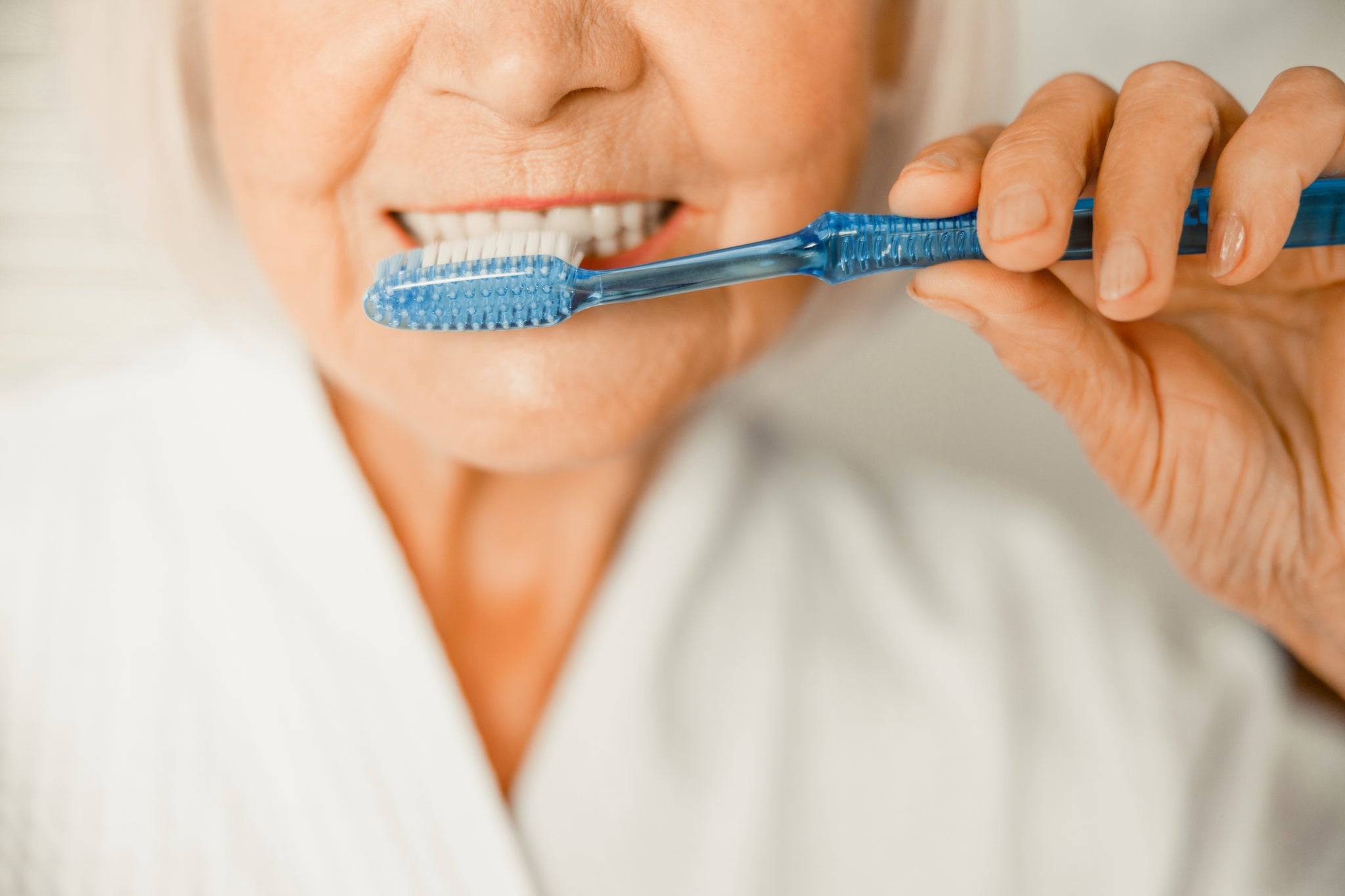 A woman brushes her teeth.