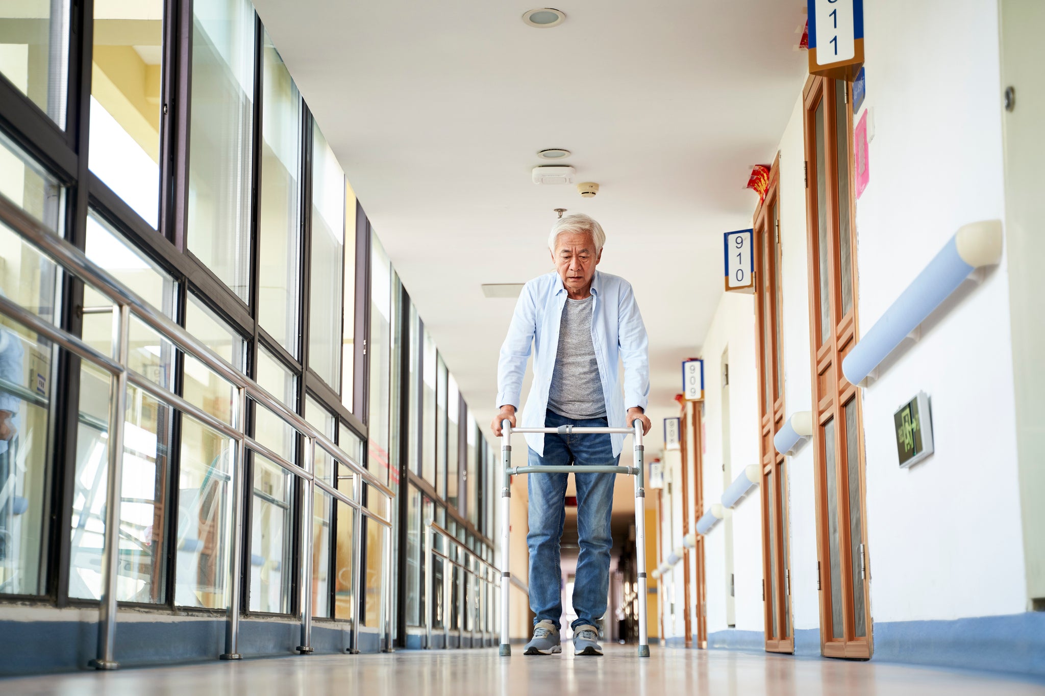 A man walks down a hallway with a walker.