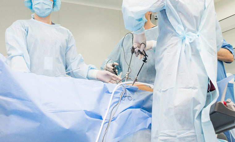 A team of doctors performs surgery using laparoscopic tools.