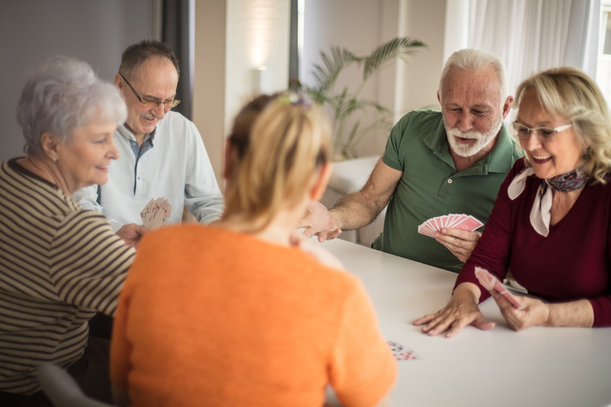 A group of people play cards.