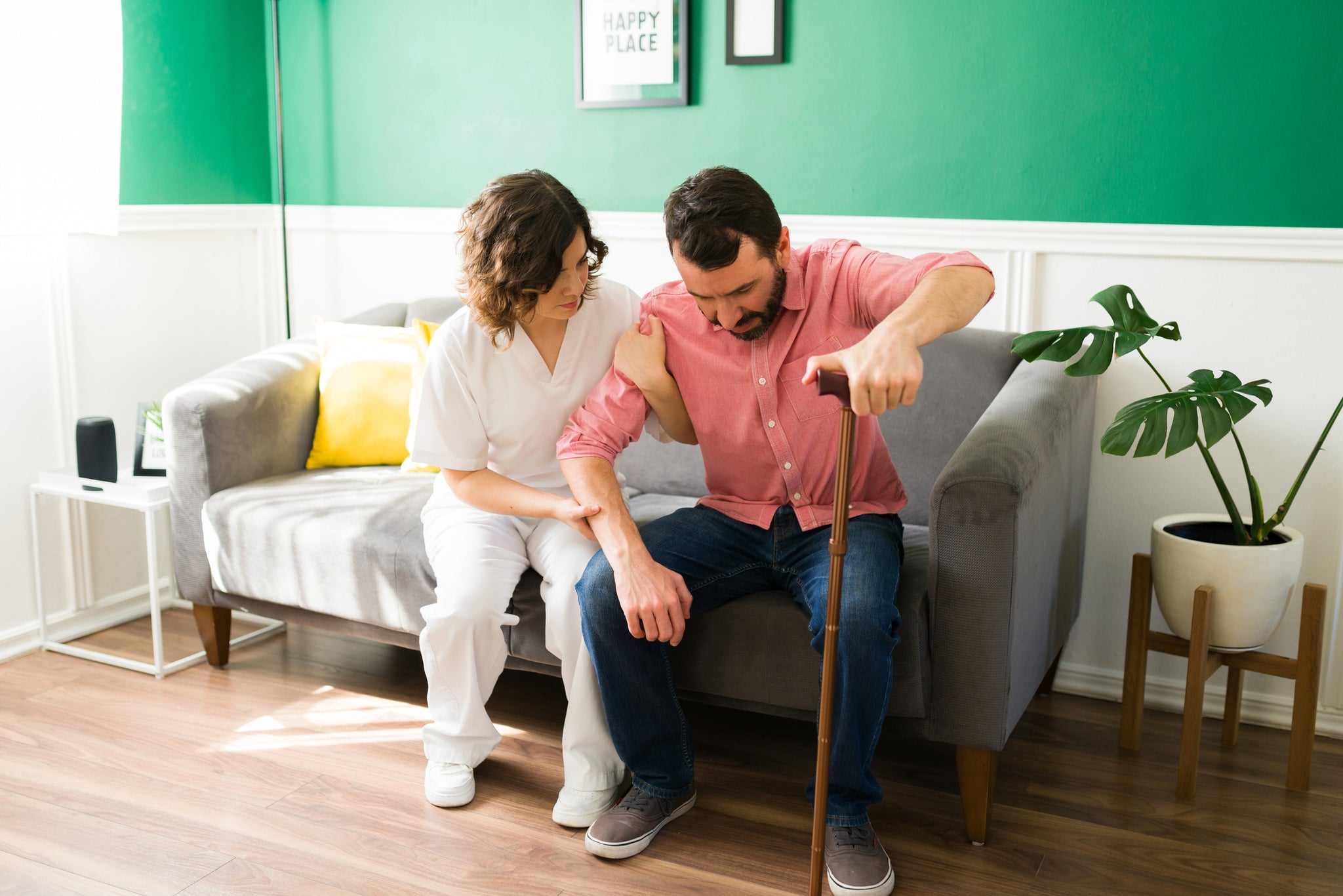 A man sits using a cane.