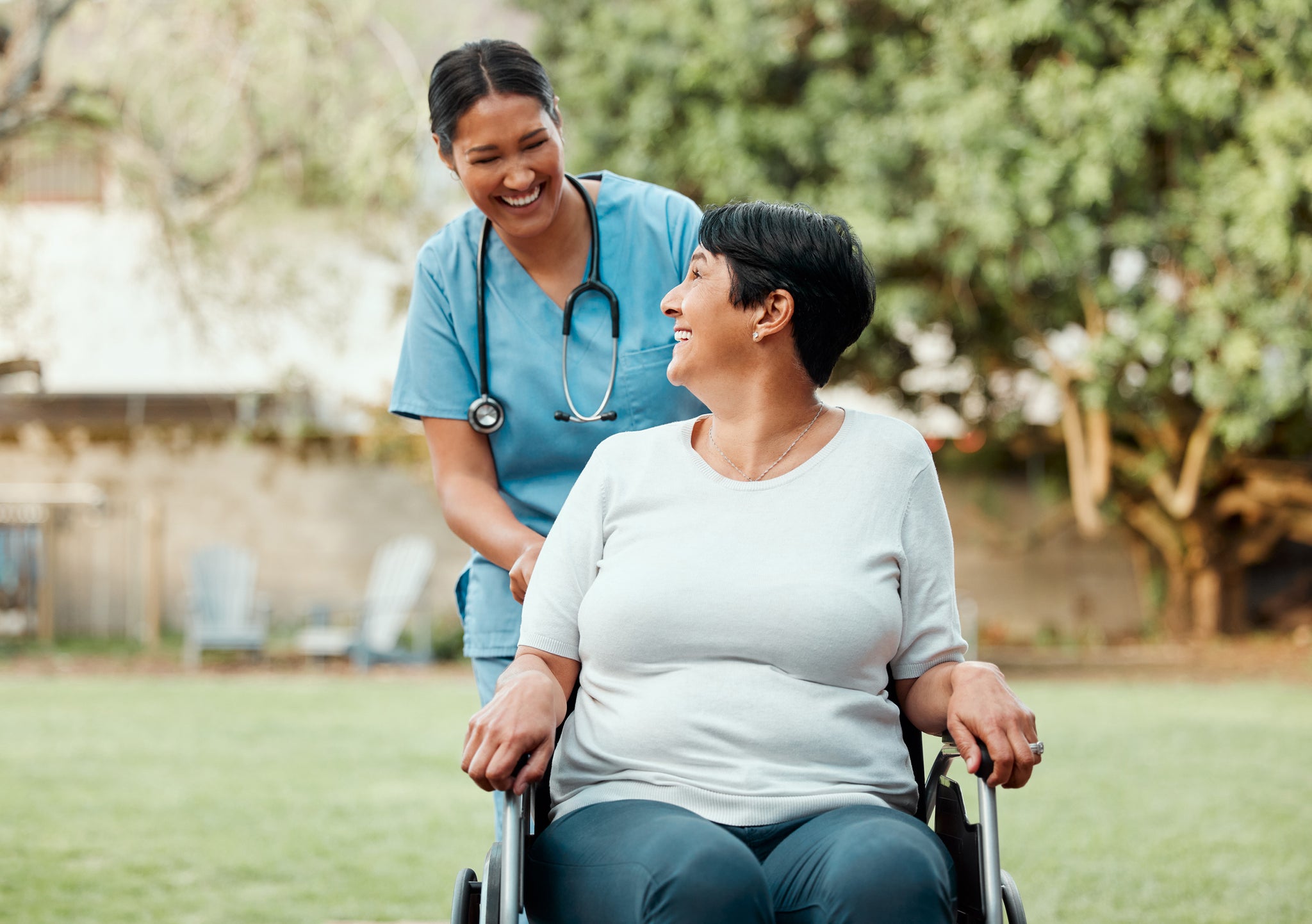 Its an industry of compassion - caregiver pushing a woman on wheelchair.