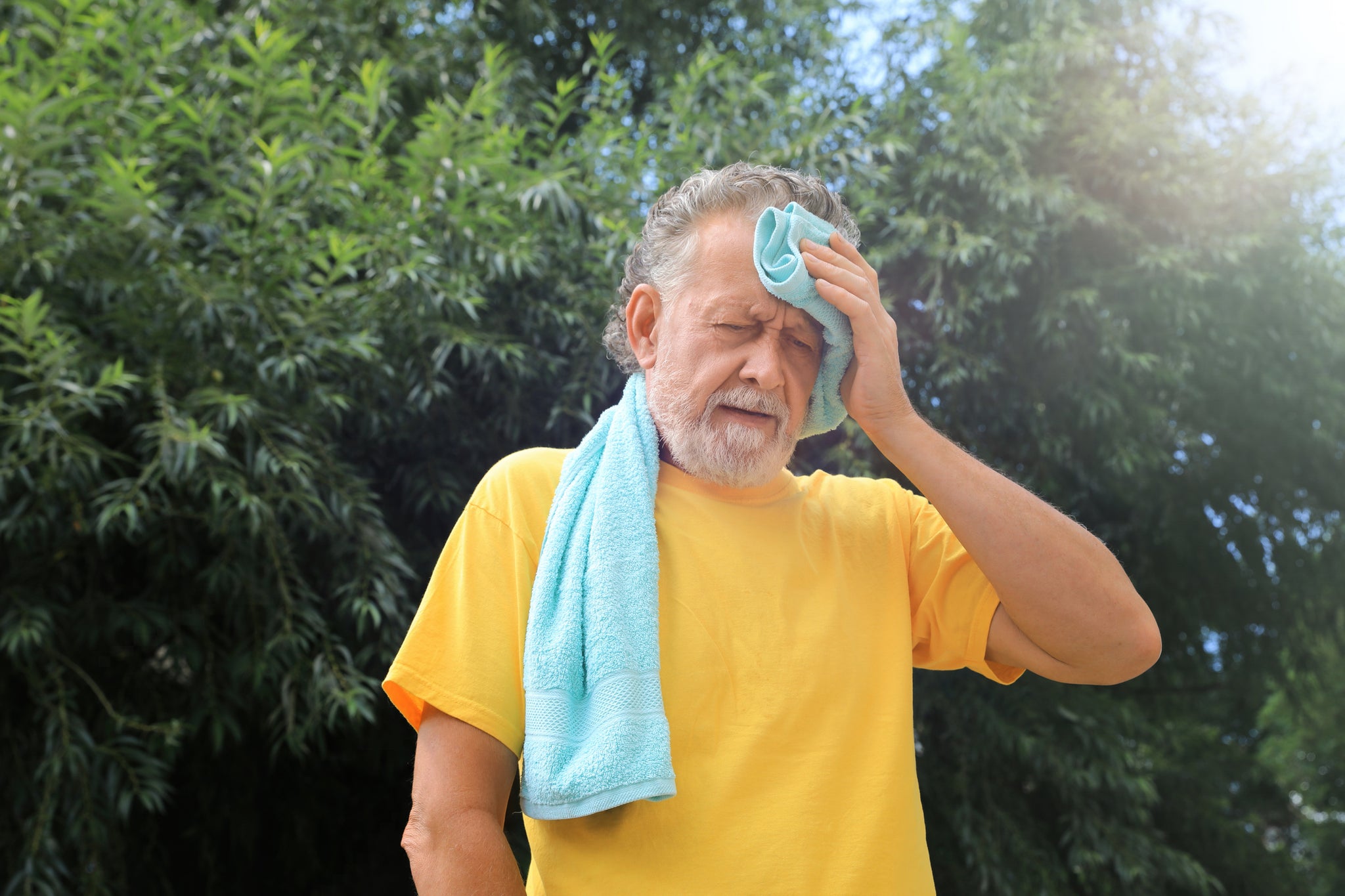 A man wipes sweat with a towel.