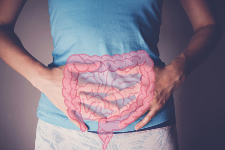 A person stands holding their stomach. An illustration of the intestinal tract is overlayed.