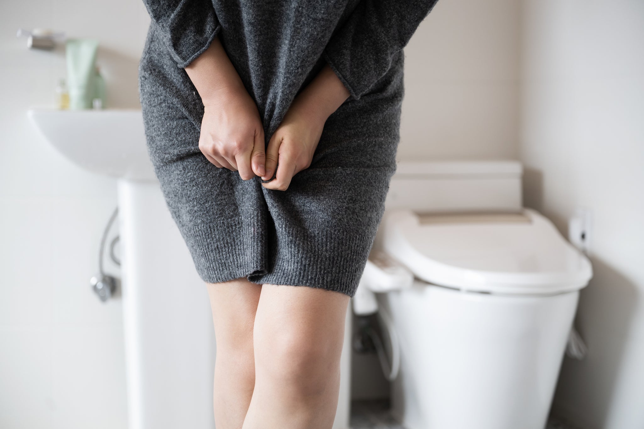 A woman in pain in the bathroom.