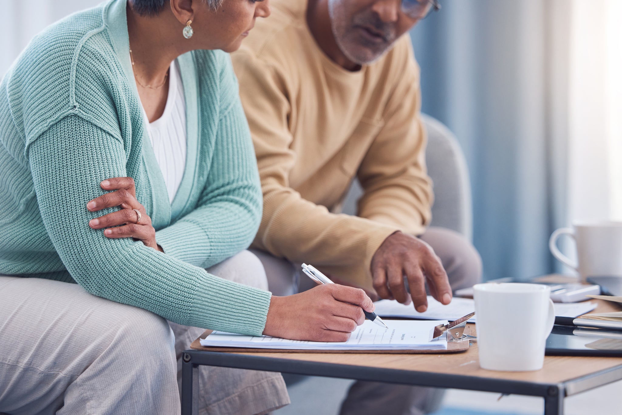 An older couple sit down to sign a contract.