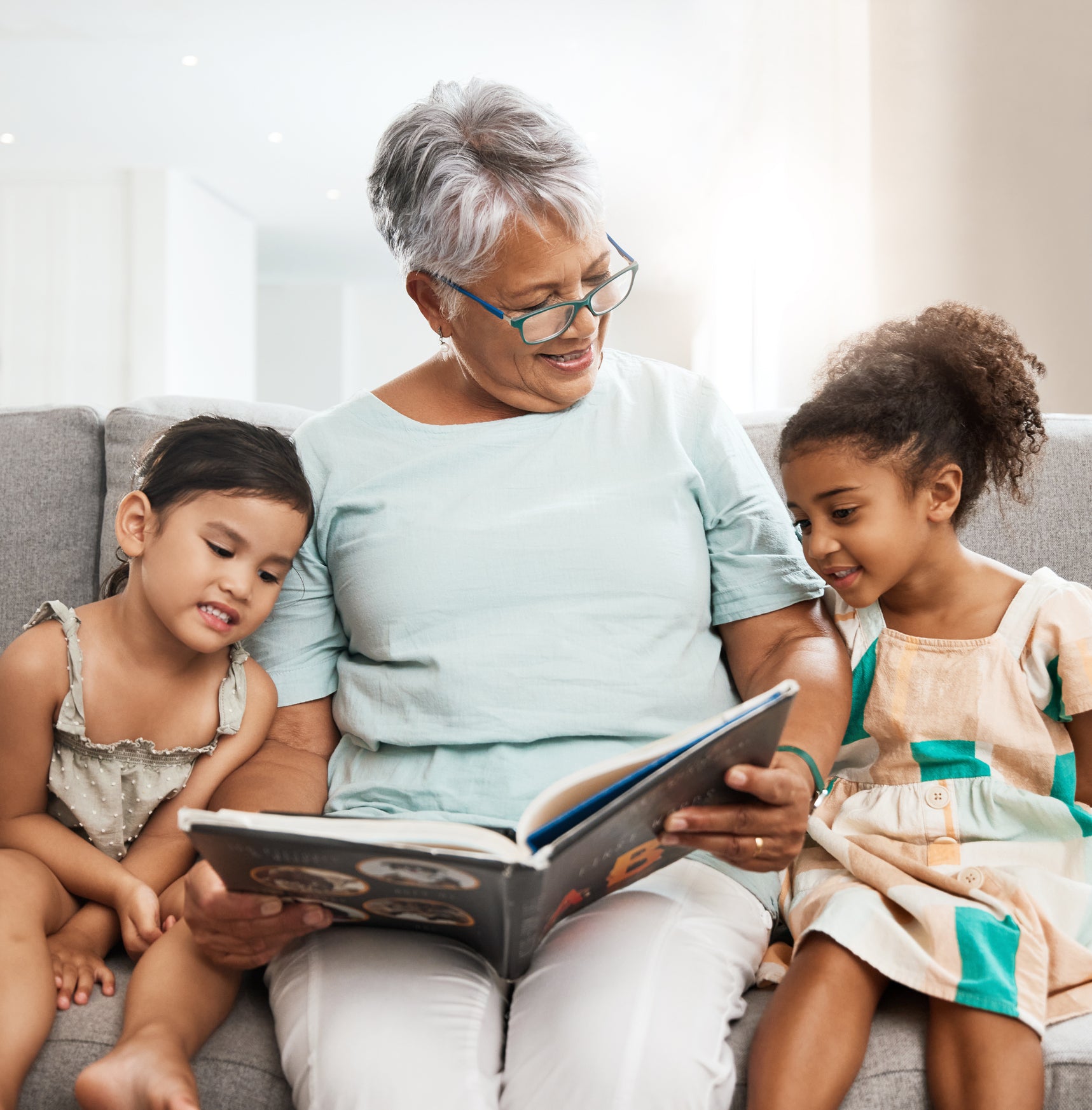 A grandmother reads to two grandchildren.