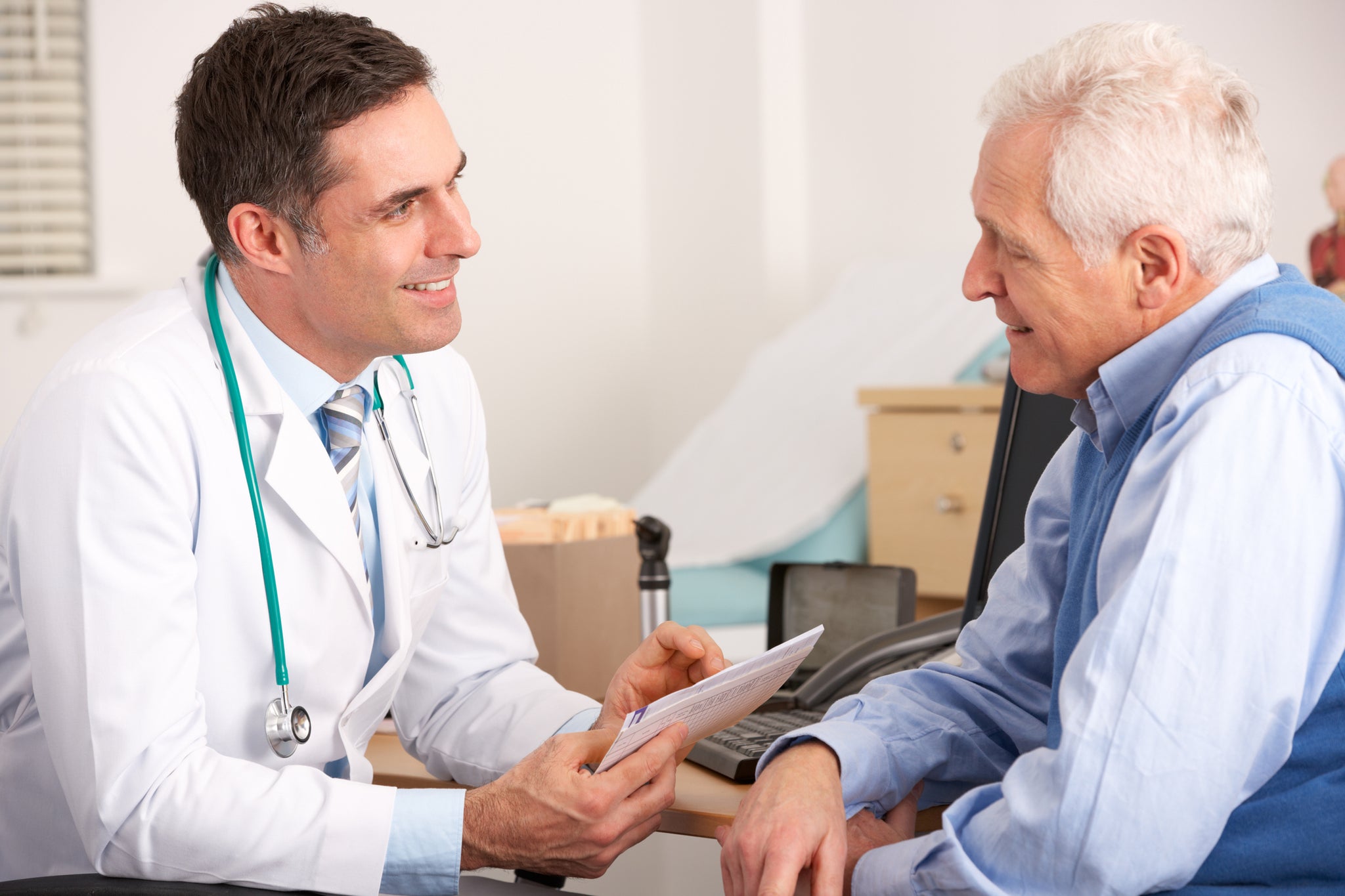 American doctor talking with a senior man in surgery smiling