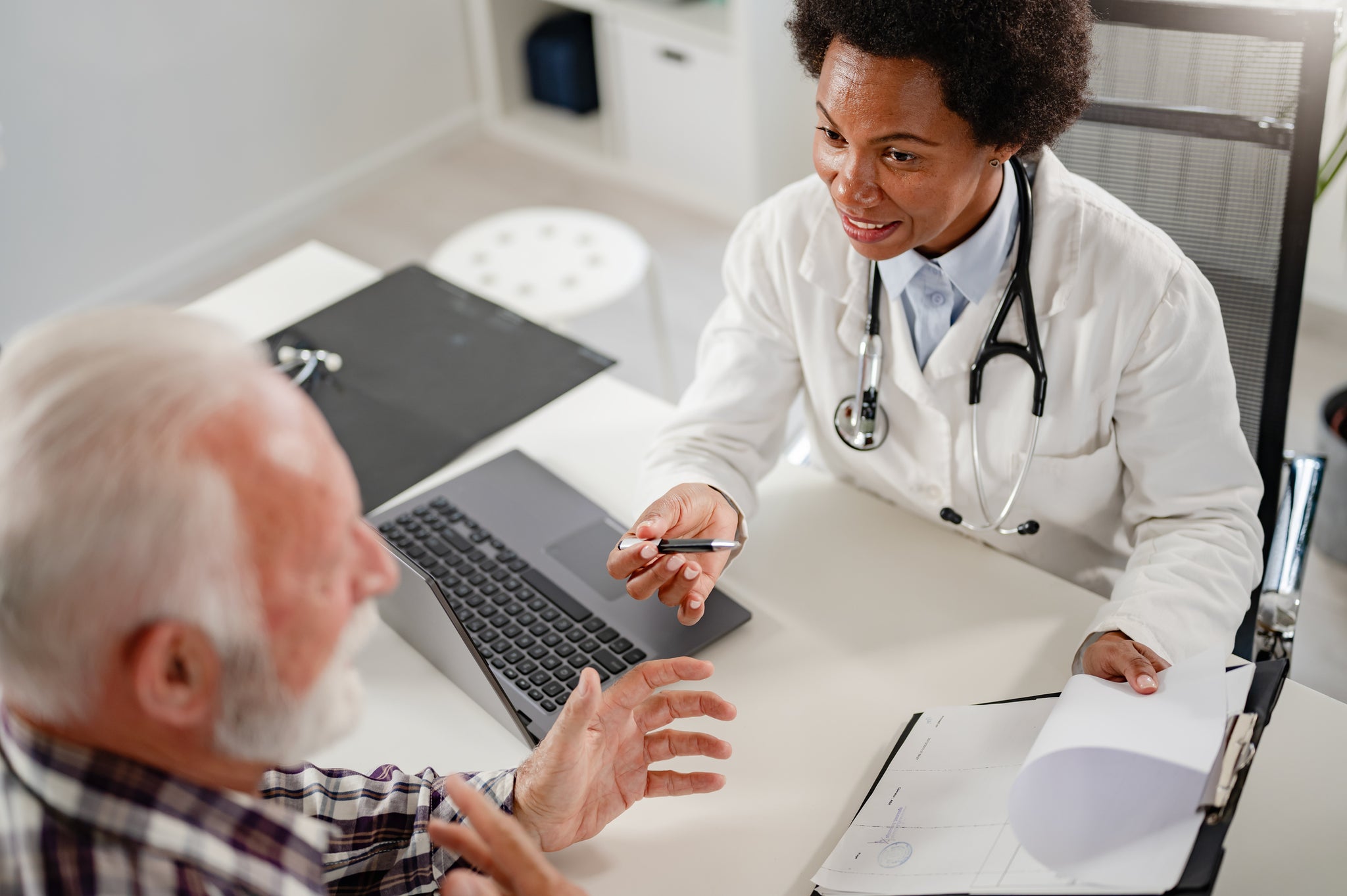 A doctor and a patient discuss a file.