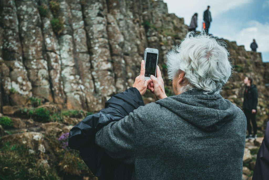 A woman takes a picture of nature.