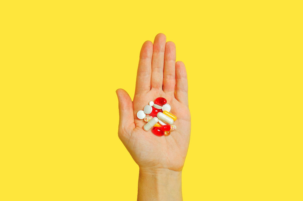 A hand holds an assortment of pills.