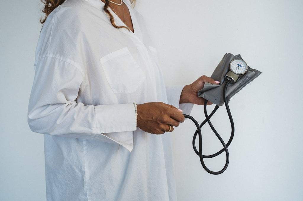 A doctor holds a tool used to monitor blood pressure.