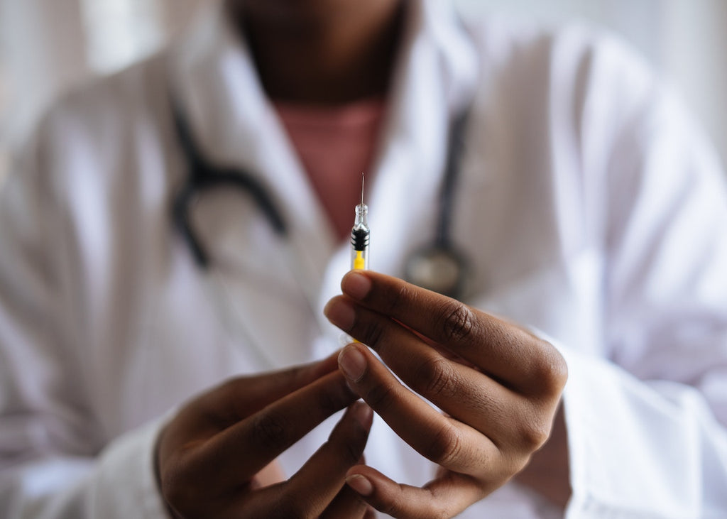 A doctor holds a needle.