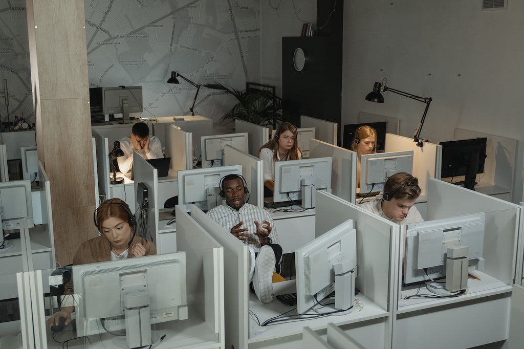 People sit in cubicles in a call center.