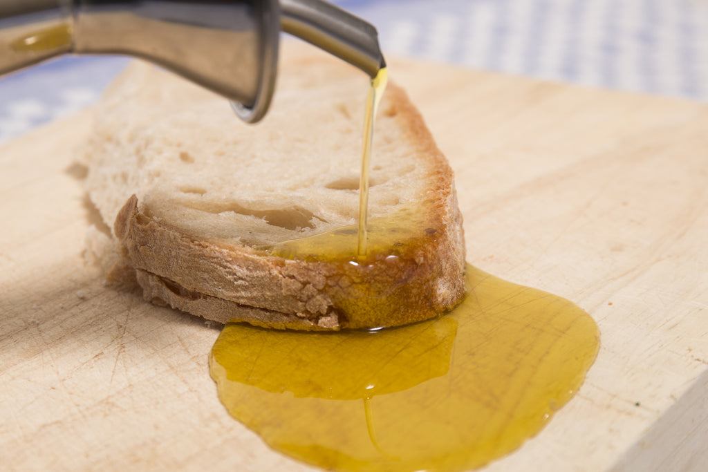 Pouring olive oil on a slice of Alentejo bread