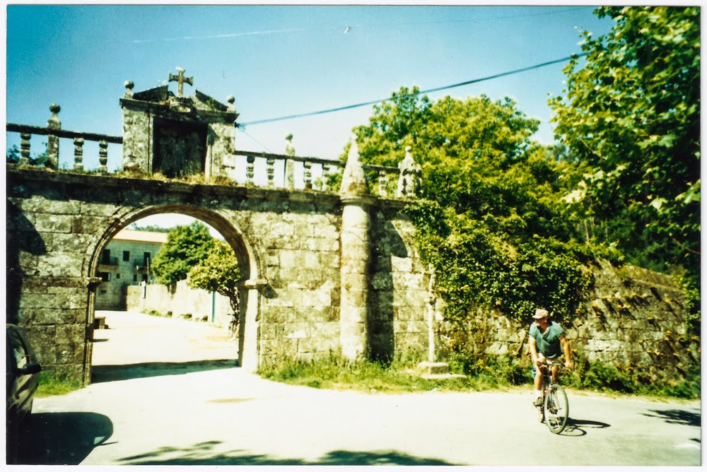 Cyclist riding under a old granite arch in the Minho region in Portugal