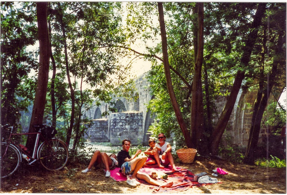 Group of friends reclining by a river on the Minho valley bike tour in Portugal