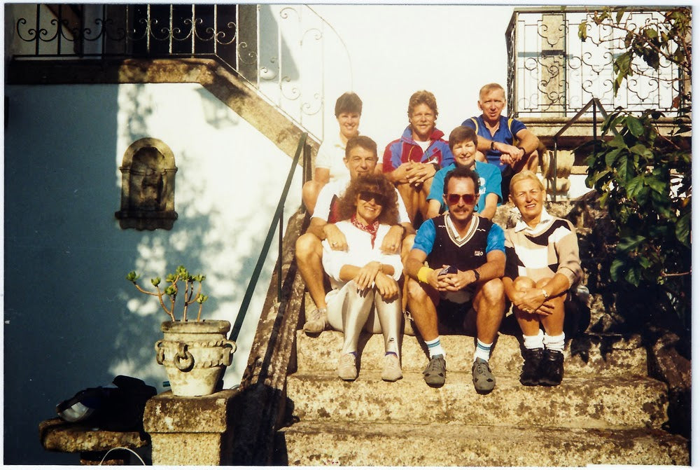 Group of friends sitting on the steps of an old manor house on a bike tour in Portugal