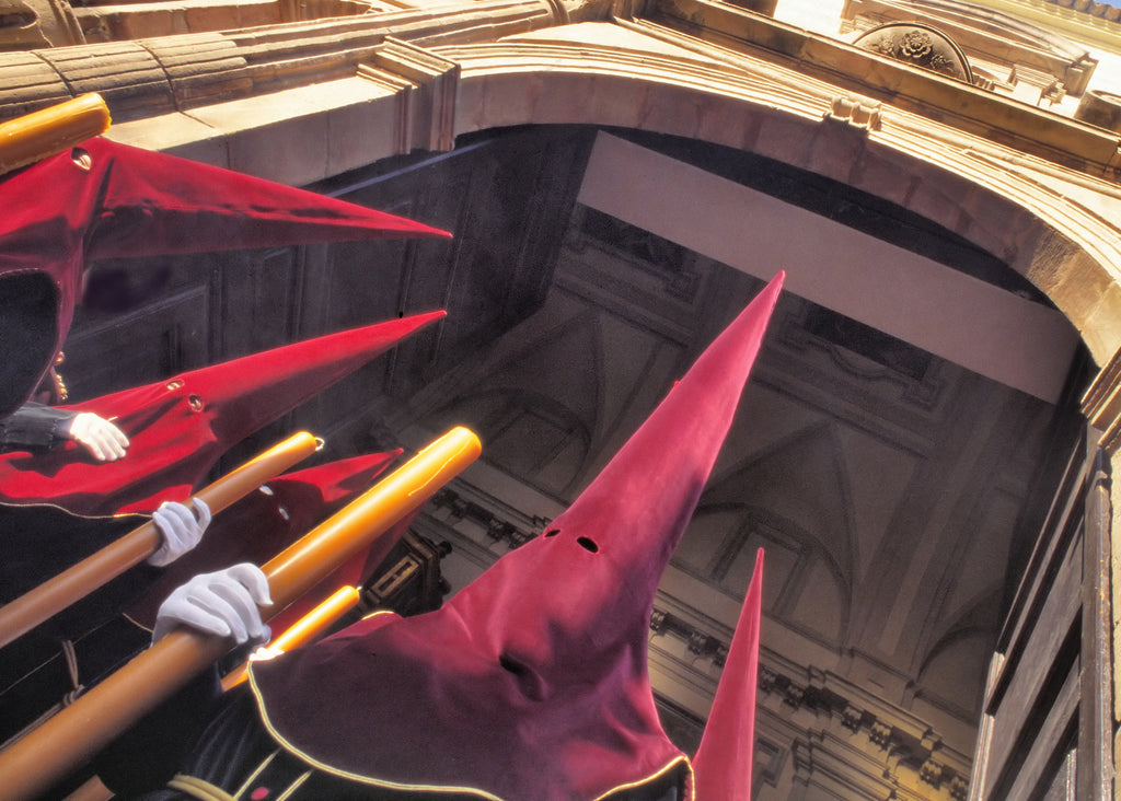 Penitentes wearing red velvet hoods during Semana Santa in Spain