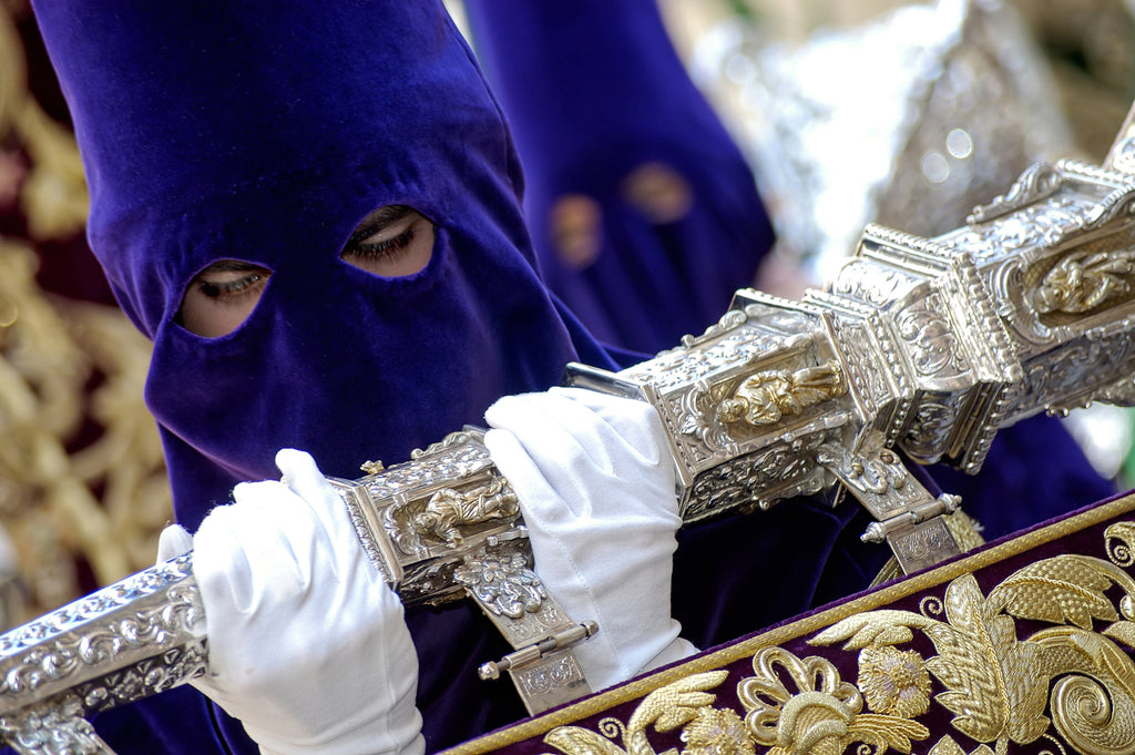 Penitente holding the silver handle of a procession piece during Semana Santa in Spain