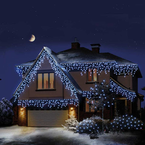 Cool White Icicle Lights for Outdoors LEDs draped around house with snow.