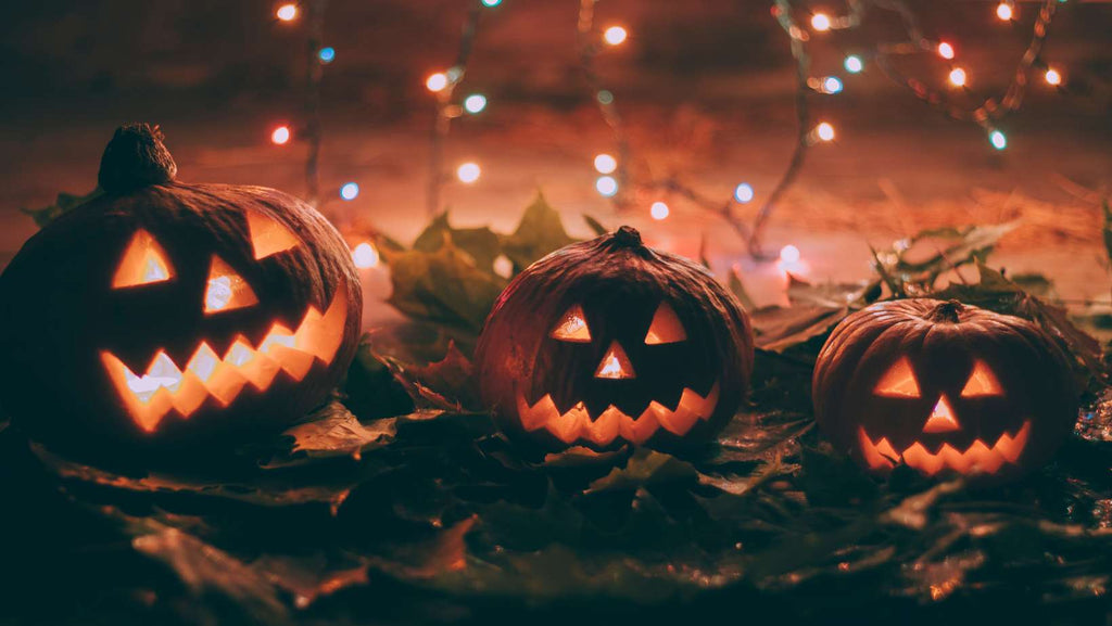 Halloween Pumpkins lit up wit coloured string lights in the background