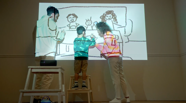 A family painting the wall by using the R150 smart projector