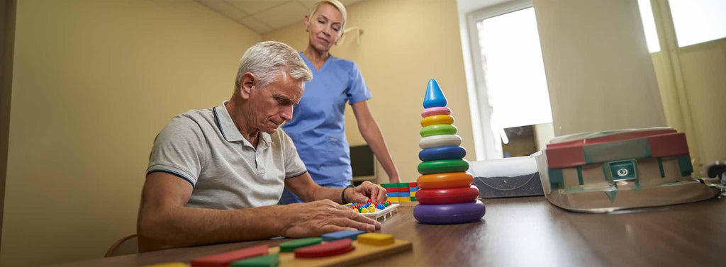 Supporting elderly man with dementia with cognitive activities.