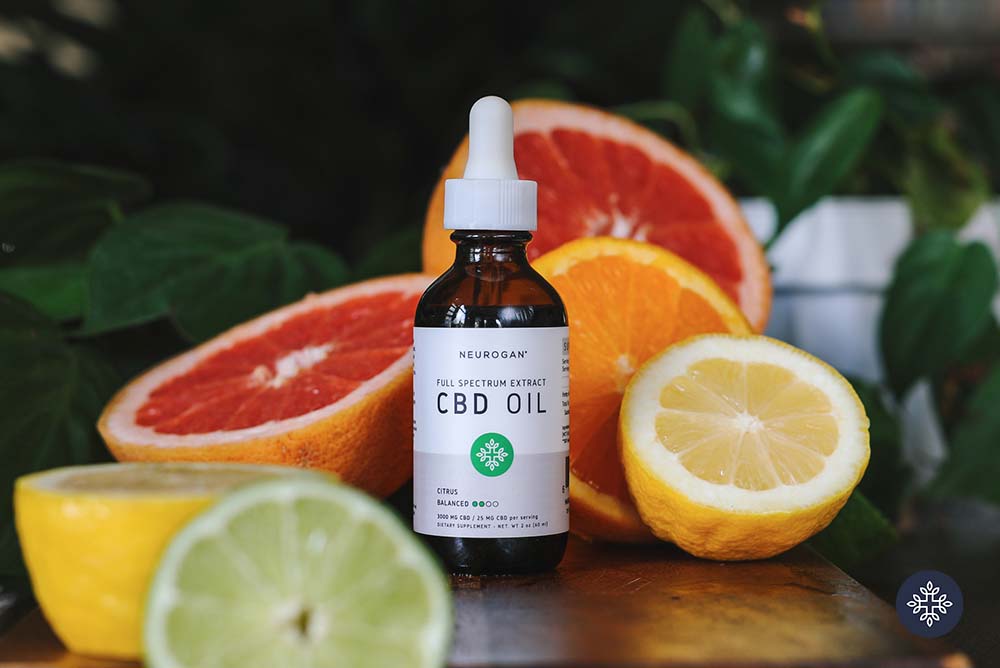 A bottle of CBD Oil surrounded by citrus