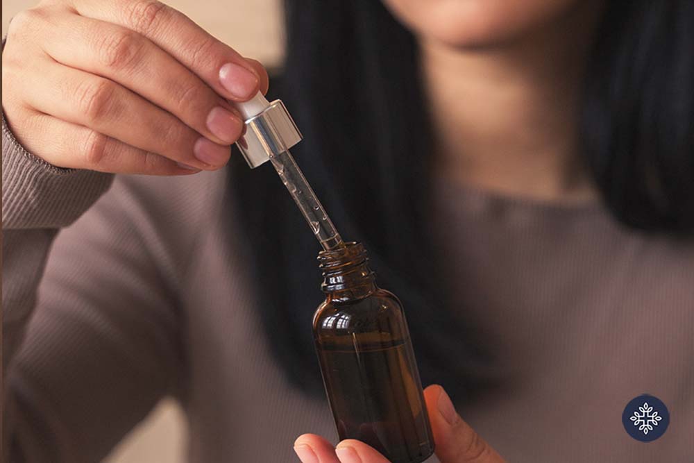 Woman holding a jar and dropper of CBD tincture