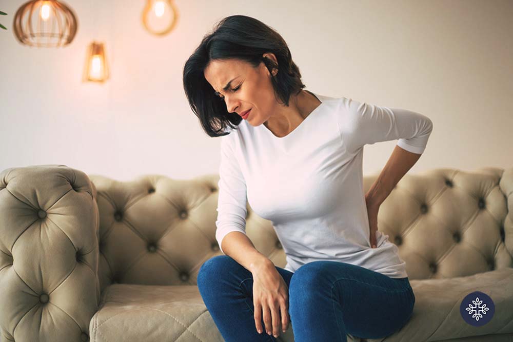 Woman holding her back with an anguished face