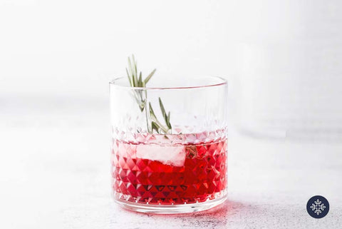 CBD Cocktails: Textured Lowball Glass with CBD Infused Hibiscus and Pomegranate Margarita with Rosemary Sprig