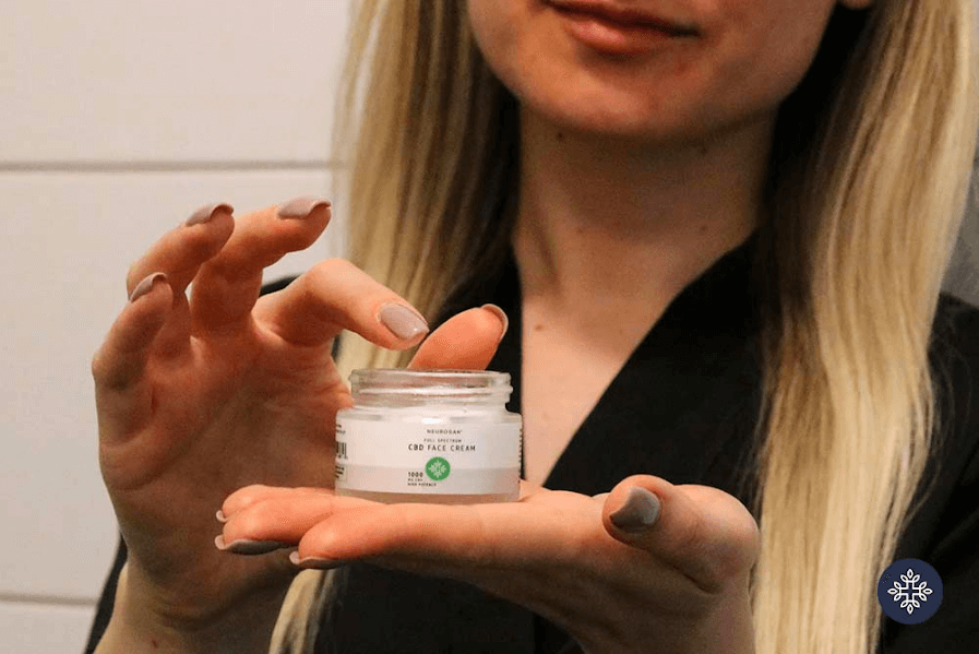 A woman holding a jar of Neurogan CBD Face Cream