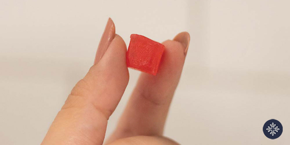 Hand holding a gummy square in two fingers