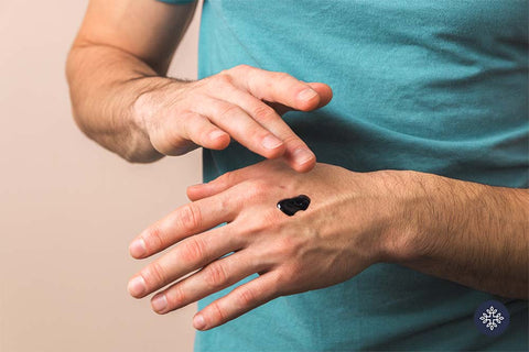 Man applying RSO oil on hand