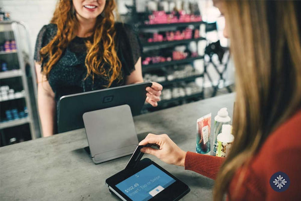 Woman shopping products at the register with a credit card.