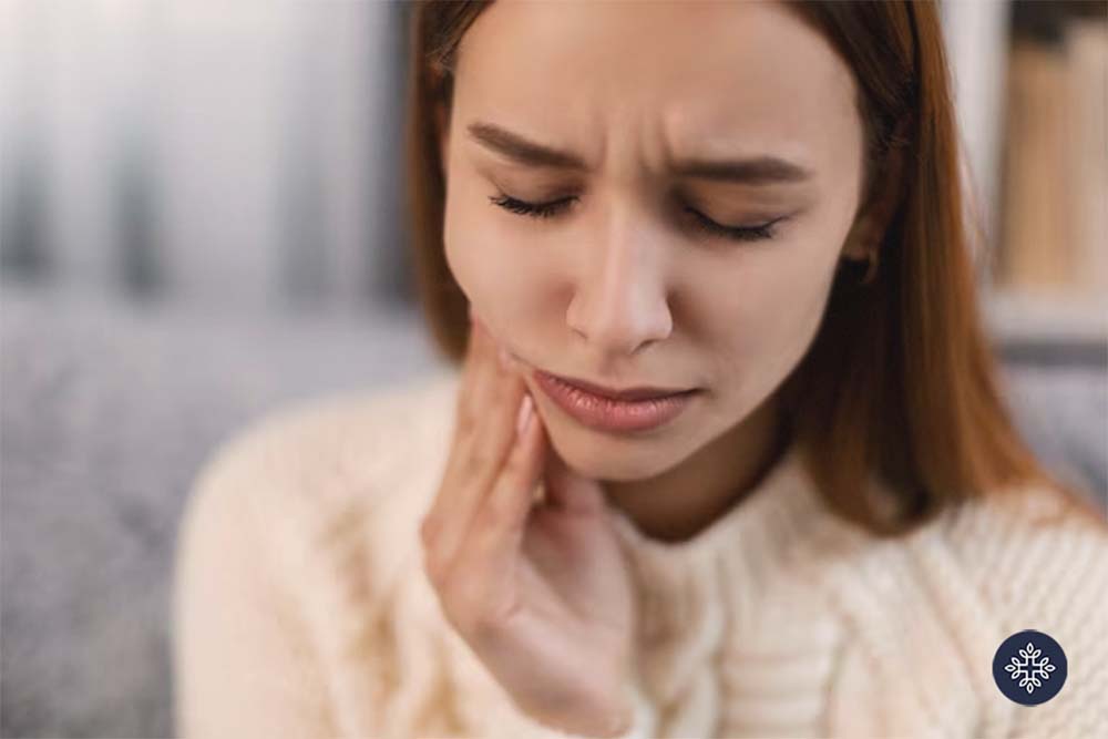 Woman holding her face because of a tooth ache