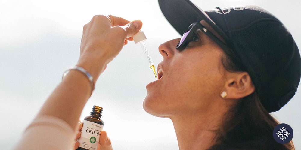 Woman holding a CBD Dropper to her mouth
