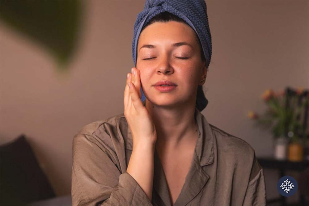 Woman applying cream to her face