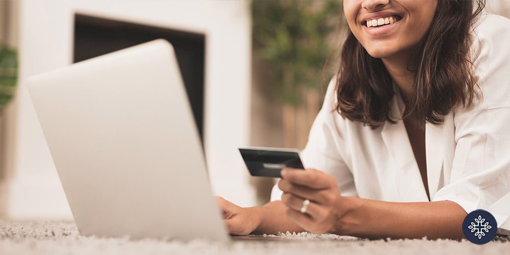 Woman purchasing online on her laptop while holding her credit card