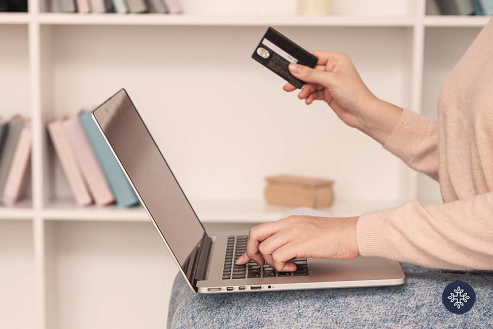 Woman online shopping with her card on hand