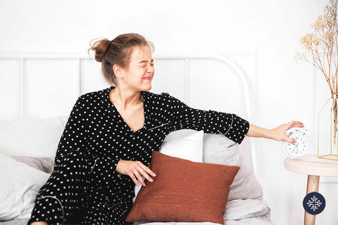 Woman waking up holding a clock