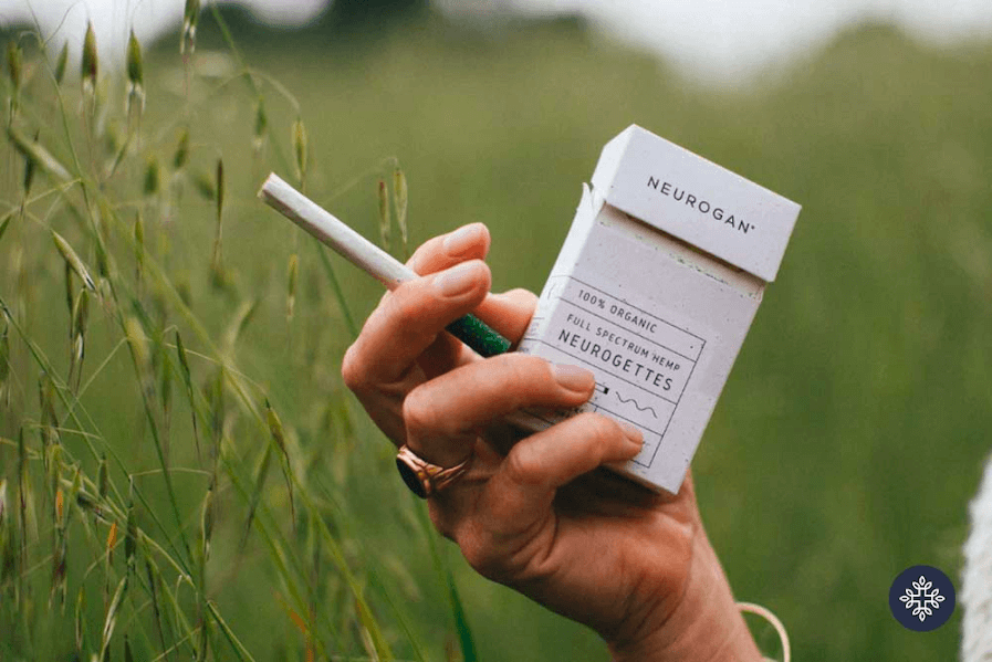 A hand holding full spectrum CBD cigarettes